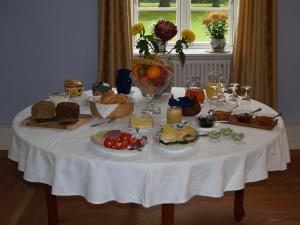 einen Tisch mit einem weißen Tischtuch mit Essen drauf in der Unterkunft Landhaus Schloss Kölzow in Kölzow