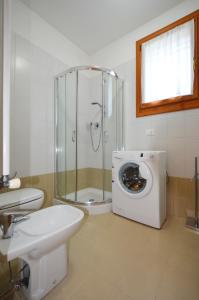 ein Bad mit einer Dusche und einer Waschmaschine in der Unterkunft Magica immobiliare - Milano Dune 33 in Lido di Jesolo