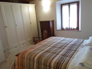 1 dormitorio con cama y ventana en Appartamento La Volpe, en Pian degli Ontani