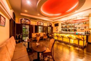 een bar met een bank en stoelen in een kamer bij Royal Orchid Metropole Mysore in Mysore