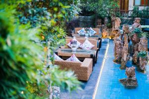 a patio with tables and chairs in a garden at The Ritz-Man Boutique Inn Lijiang in Lijiang