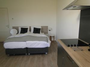 - une chambre avec un grand lit et un lavabo dans l'établissement Boerderij de Spijken, à Ammerzoden