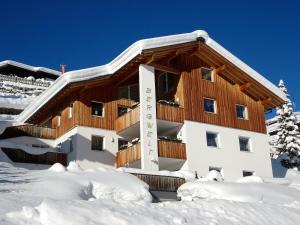 a large building with snow on the ground at Haus Bergwelt - Appartements in Lech am Arlberg