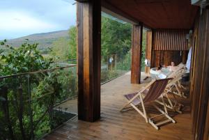 a deck with chairs and a table on a house at Mirasol Résidence in Enveitg