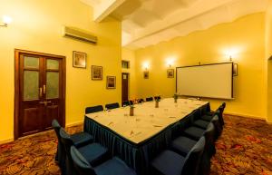 uma sala de conferências com uma mesa grande e um quadro branco em Royal Orchid Metropole Mysore em Mysore