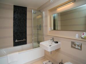 a bathroom with a sink and a shower and a mirror at Lensfield Hotel in Cambridge +43 photos