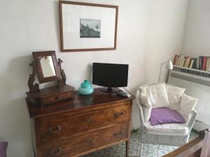 a desk with a computer on a dresser with a chair at Casa Letizia Amalfi Coast in Atrani