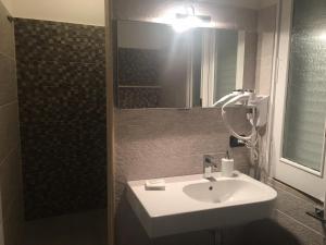 a bathroom with a white sink and a mirror at B&B Fiori di Lava in Nicolosi