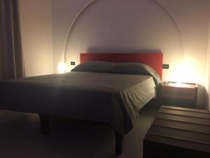 a bedroom with a large bed with a red headboard at B&B Fiori di Lava in Nicolosi