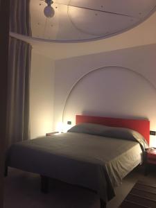 a bedroom with a large bed with a red headboard at B&B Fiori di Lava in Nicolosi