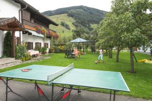 a ping pong table in a yard with people playing at Mosshamhof in Saalfelden am Steinernen Meer