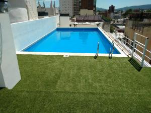 una piscina en la azotea de un edificio con césped verde en Hermoso Departamento Céntrico en Villa Carlos Paz