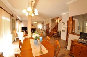 a dining room and living room with a table and chairs at Villa Tango in Paleokastritsa