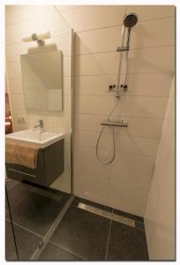 a bathroom with a shower with a sink and a mirror at B&B, Brasserie Lakerhof in Ohé en Laak