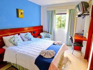 una camera da letto con un letto grande con una parete blu di De La Costa Hotel a Encarnación