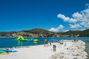 un grupo de personas en una playa cerca del agua en Apartments Neve, en Marina