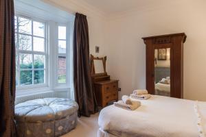 ein Schlafzimmer mit einem Bett und einem großen Fenster in der Unterkunft Apartment 3 The Grove in Durham