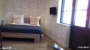 un dormitorio con una cama con dos almohadas. en Appart'Hotel Parc Johan, en Chauffailles 18 fotos más