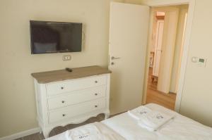 1 dormitorio con tocador y TV en la pared en Residence Bilyana en Svilengrad