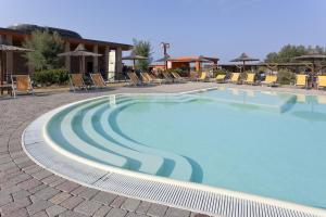 a large swimming pool with chairs and umbrellas at Toscana Sport Resort in Tirrenia