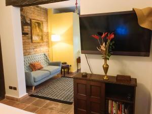 ein Wohnzimmer mit einem Sofa und einem TV in der Unterkunft Magic Garden House in Cali