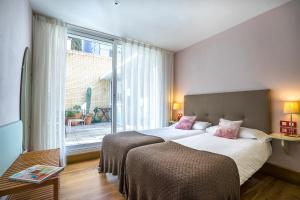 a bedroom with two beds and a large window at Friendly Rentals Olimpic Beach in Barcelona