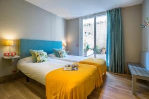 sypialnia z 2 łóżkami z żółtą pościelą i oknem w obiekcie Friendly Rentals Olimpic Beach w Barcelonie