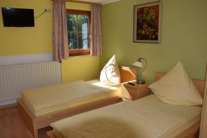 two twin beds in a room with a window at Camping de L'Our Appartements in Vianden