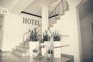 a hotel lobby with potted plants on the stairs at Hotel & Spa Arkadia in Tomaszów Lubelski