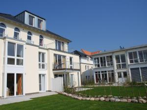 eine Reihe weißer Gebäude mit einem Hof in der Unterkunft Haus Möwe - Apt. 03 in Ostseebad Sellin