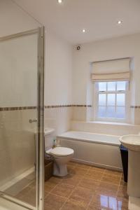 uma casa de banho com uma banheira, um WC e um lavatório. em Apartment 3 The Grove em Durham