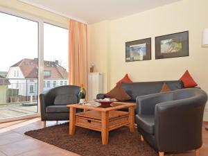 ein Wohnzimmer mit 2 Stühlen, einem Sofa und einem Tisch in der Unterkunft Haus Möwe - Apt. 05 in Ostseebad Sellin