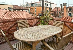 a wooden table and two chairs on a balcony at altana san marco in Venice