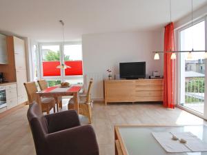 eine Küche und ein Wohnzimmer mit einem Tisch und einem TV in der Unterkunft Haus Möwe - Apt. 06 in Ostseebad Sellin