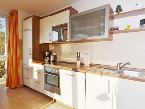 eine Küche mit weißen Schränken und einer Spüle in der Unterkunft Haus Möwe - Apt. 07 in Ostseebad Sellin + 10 Fotos