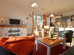 ein Wohnzimmer mit Tisch und Küche in der Unterkunft Haus Möwe - Apt. 07 in Ostseebad Sellin
