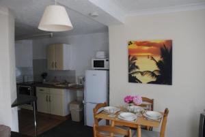 a kitchen with a table and a white refrigerator at Ashbury Tor in Torquay