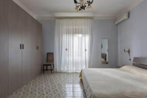 トッレ・ラピッロにあるAppartamenti delle rose by BarbarHouseのベッドルーム1室(ベッド1台、窓、椅子付)