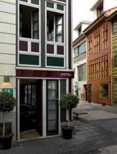 un edificio de hotel en una calle con dos macetas en La Plaza I, en Luanco