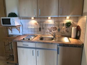 a kitchen with a sink and a microwave at Ferienwohnung Hage in Hage