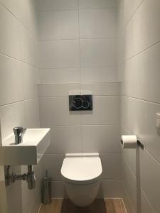 ein weißes Bad mit einem WC und einem Waschbecken in der Unterkunft Koningshof XL in Alkmaar