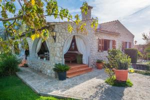 een huis met een stenen huis met een veranda bij Finca SA VINYETA in Selva