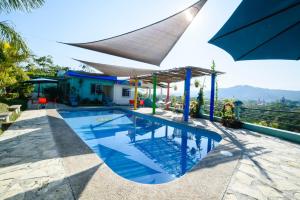 a villa with a swimming pool and an umbrella at Mirador del Castillo in Tenexcalco