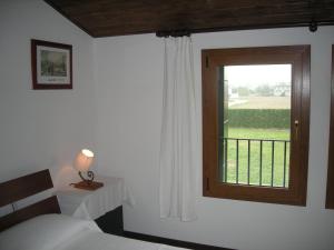 a bedroom with a bed and a window with a view at Temporin Ospitalità in Monselice