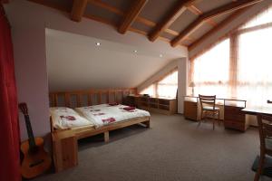 Un dormitorio con una cama y una guitarra en una habitación en Penzion SURF, en Blansko