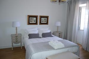 a bedroom with a large bed with two tables and two lamps at Quinta do Piloto in Palmela