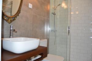 W łazience znajduje się umywalka i przeszklony prysznic. w obiekcie Quinta do Piloto w mieście Palmela