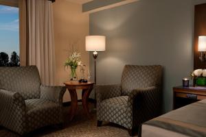 a hotel room with two chairs and a table and a bed at Millennium Durham in Durham