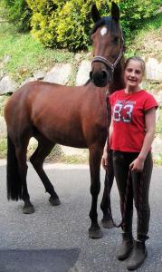 uma jovem ao lado de um cavalo castanho em Schwoererhof em Schweighausen