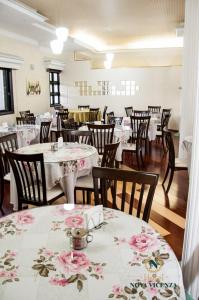 un restaurante con mesas y sillas con flores rosas. en Nova Vicenza Hotel, en Farroupilha